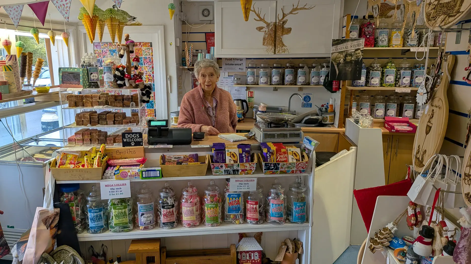 The shopkeeper welcoming visitors among local handmade crafts and sweets